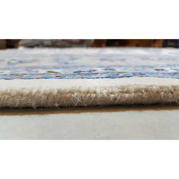 Carpet edge with a short pile and colorful border patterns in blue and cream