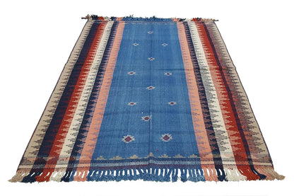 Blue striped rug with fringes, a geometric pattern, and decorative edges