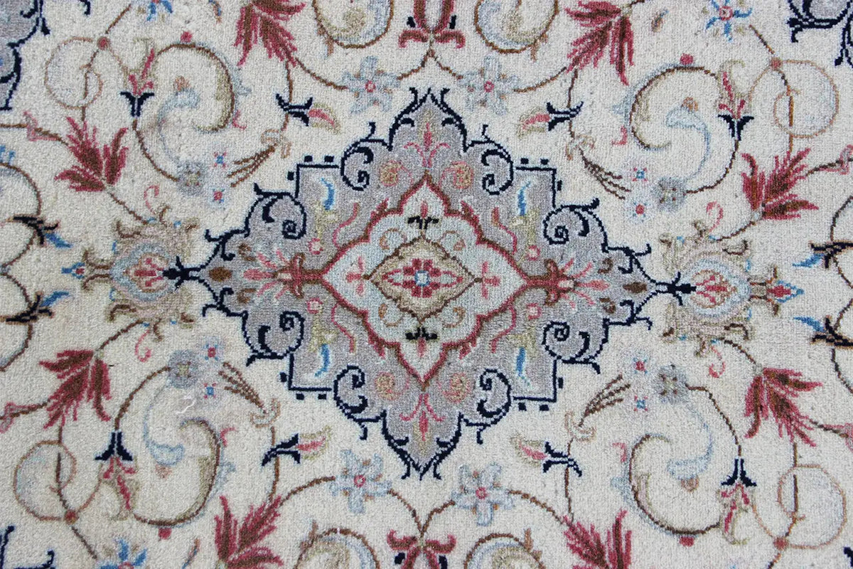 Keshan rug detail: beige base pattern with blue and red vine ornamentation