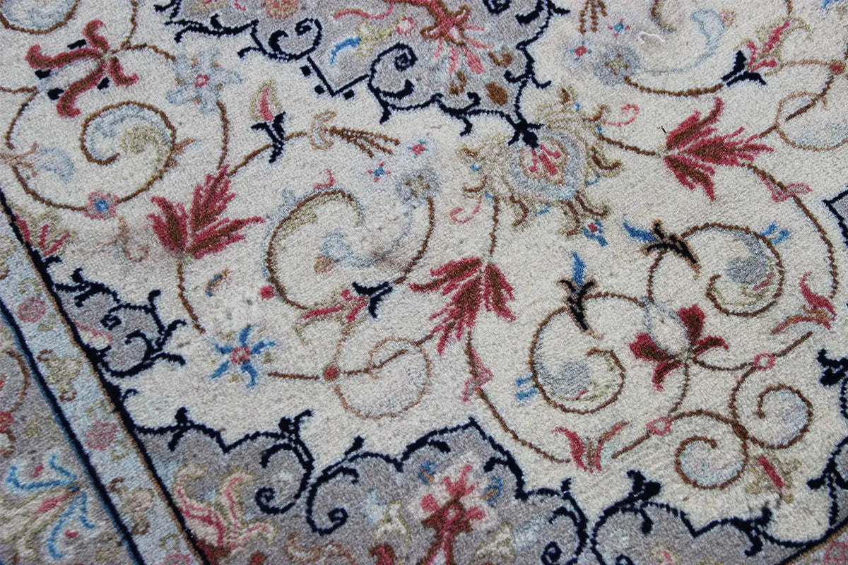 Keshan rug detail: beige pile with red flowers and blue linear ornaments