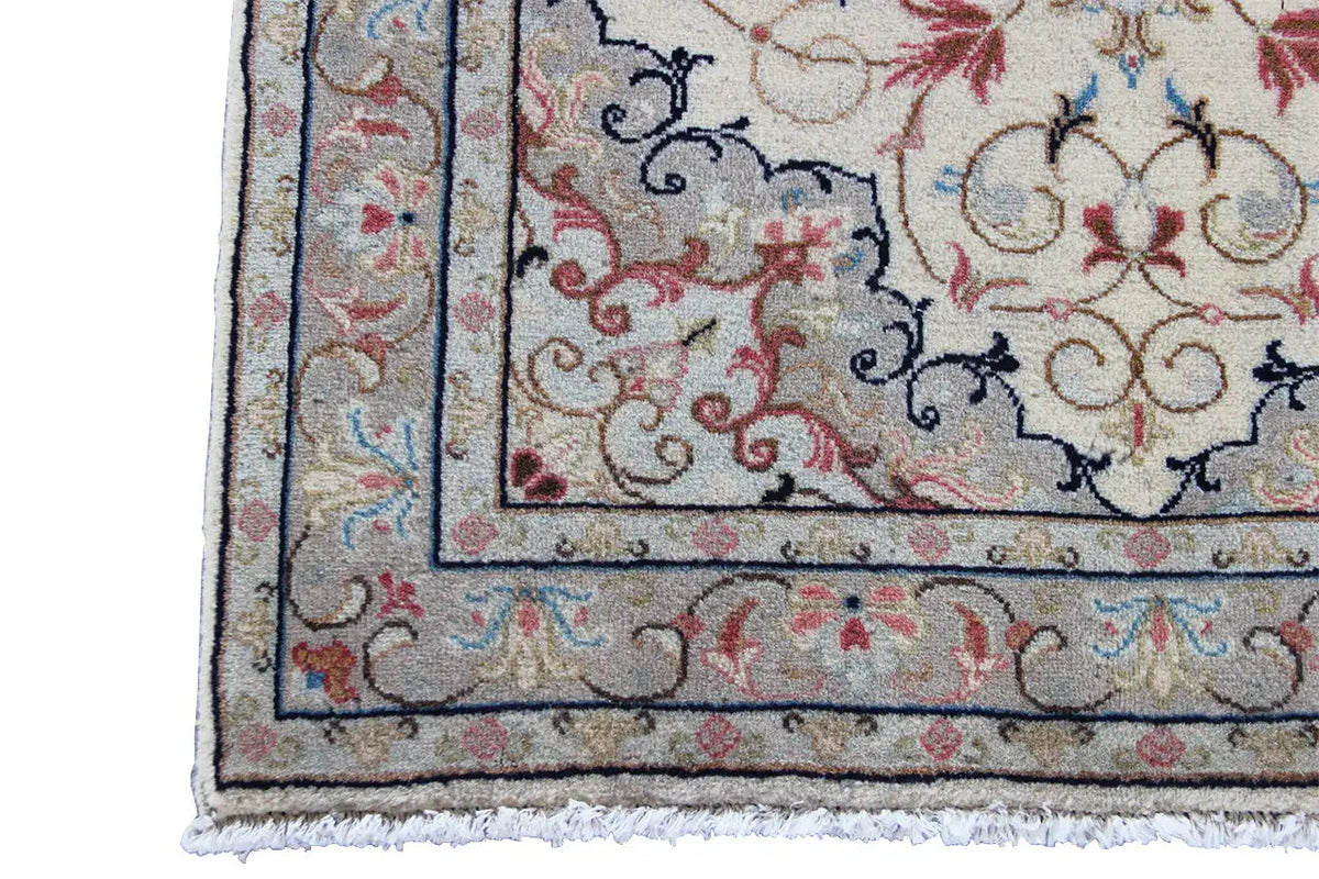 Keshan rug border detail with frame lines, a beige background, and red/blue accents