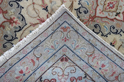 Keshan rug corner detail with fringes, beige pattern and blue-red ornamental design