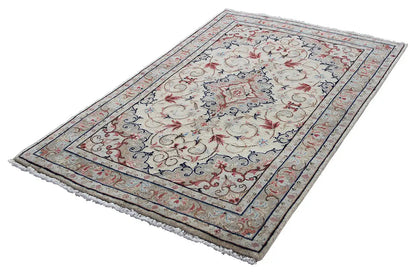 Beige Oriental rug lying flat, with a wide blue border featuring red patterns
