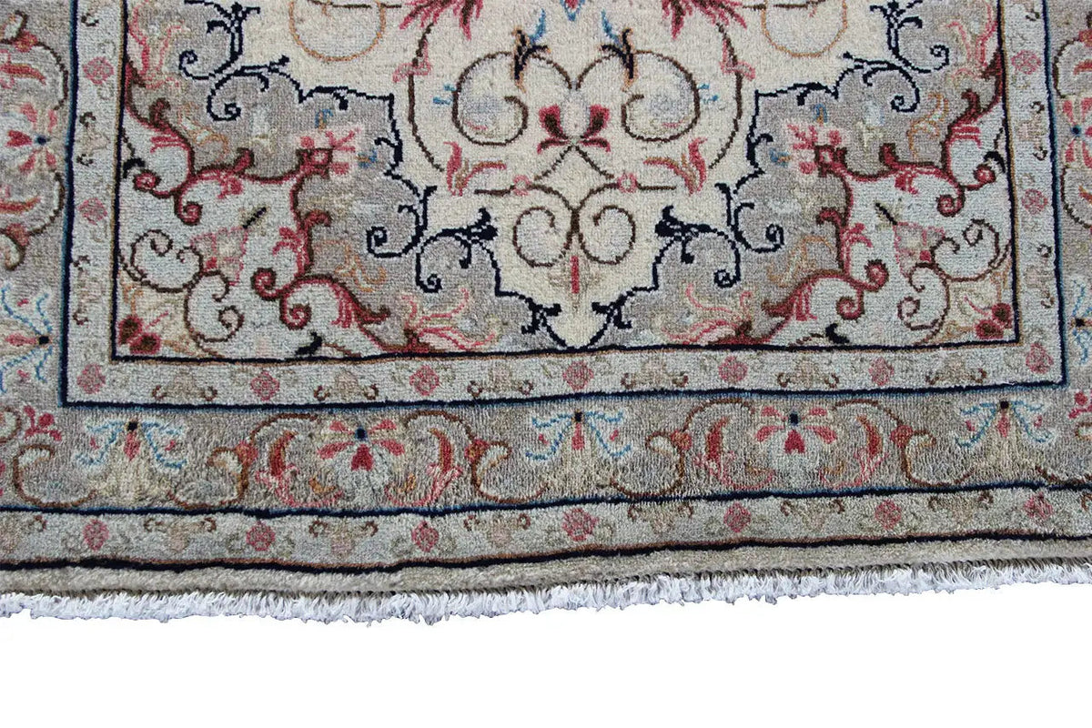 Lower edge detail: beige oriental rug with a blue patterned border and red accents