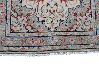 Lower edge detail: beige oriental rug with a blue patterned border and red accents