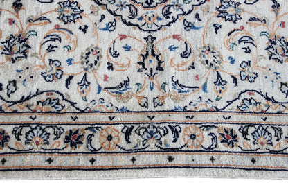 Detail of the border on the Keshan rug: pattern in blue, red, and yellow on beige