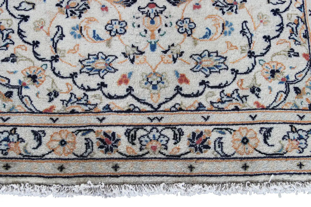 Border detail on the Keshan rug with decorative lines and fringes