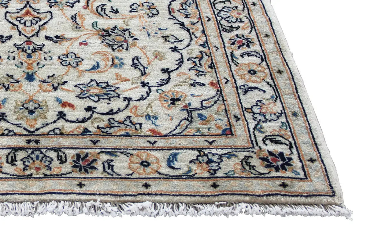 Detail of the Keshan rug: beige area with border and fringe
