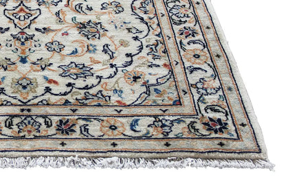 Detail of the Keshan rug: beige area with border and fringe