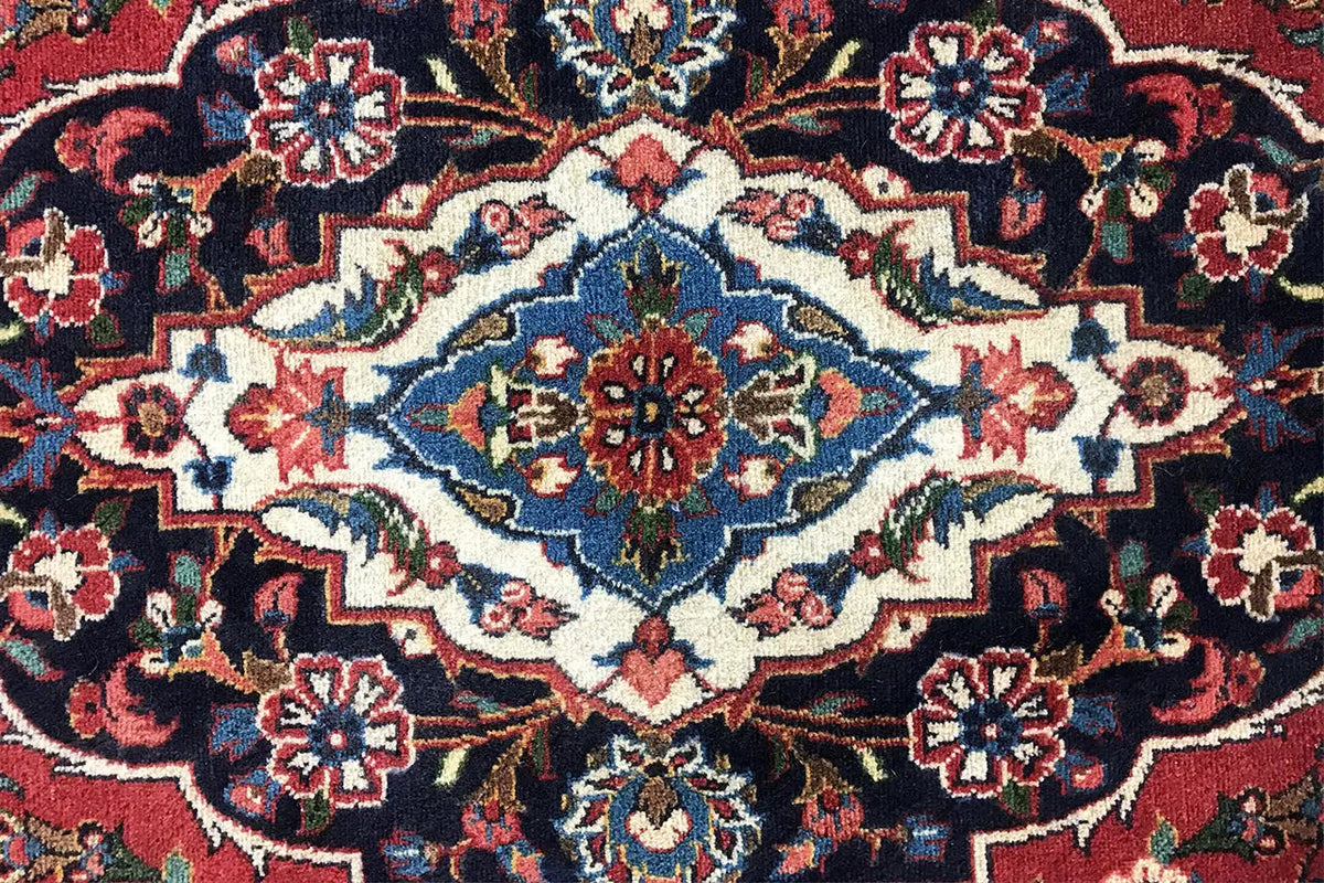 Close-up of carpet detail with a blue diamond pattern, red accents, and ornaments
