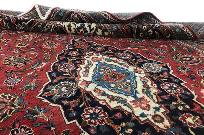 Oriental rug with a red ground and rolled edge; decorative elements in the central area