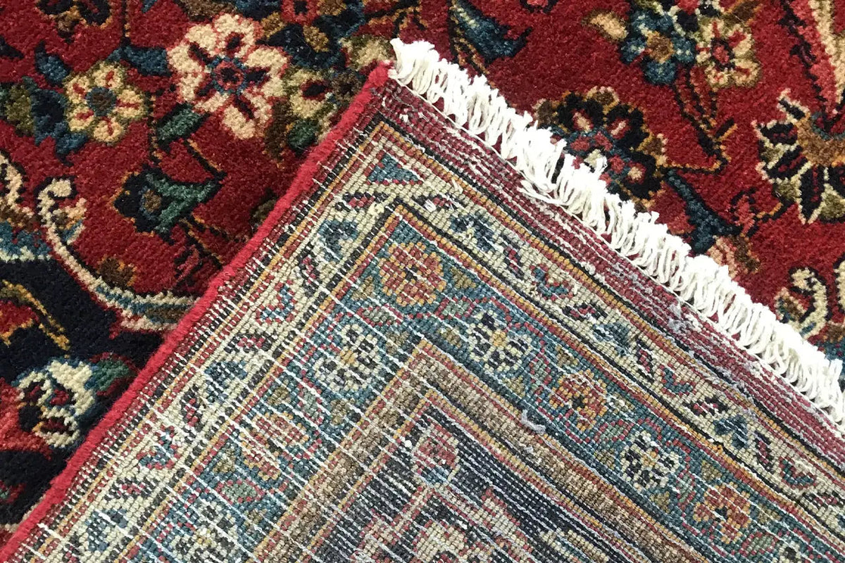 Rug border with fringe and woven texture on a red, ornamented background