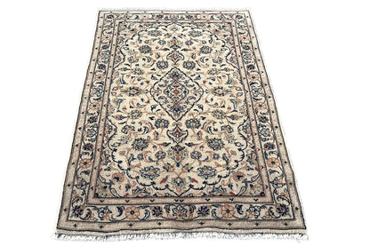 Beige Keshan rug with an ornamental floral pattern and dark border, with fringes