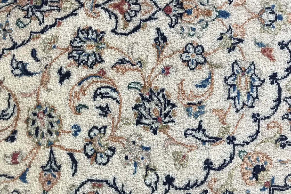 Close-up of the floral carpet pattern with dark blue and red contrast on a light background