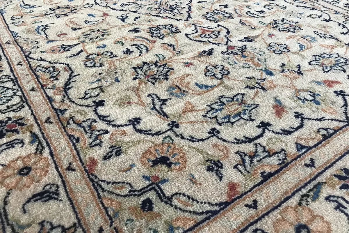 Carpet detail with an ornamental striped border and many small floral motifs in the field