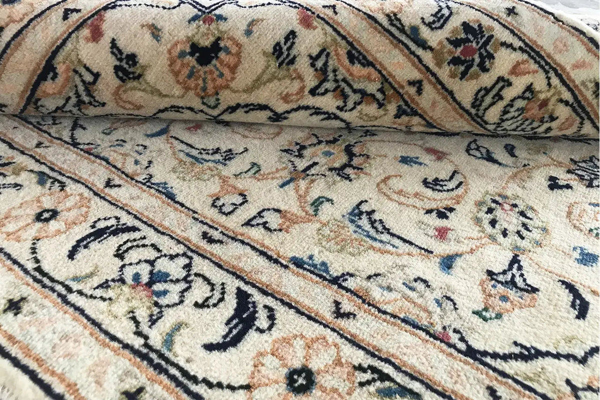 Carpet area with surrounding ornamental bands, floral motifs, and subtle color accents
