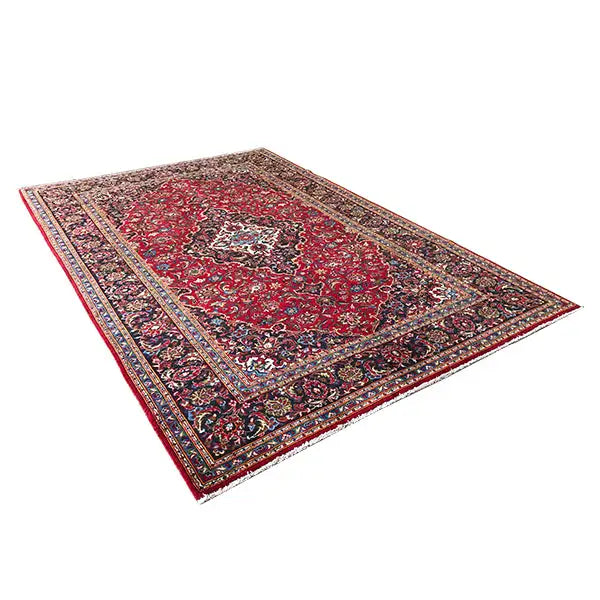 Keshan rug with a red background, floral motifs, and a dark blue decorative border