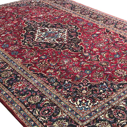 Keshan rug in red with a dark background and central medallion, richly ornamented