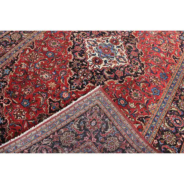 Keshan rug in red with a central medallion and intricate ornaments in detail