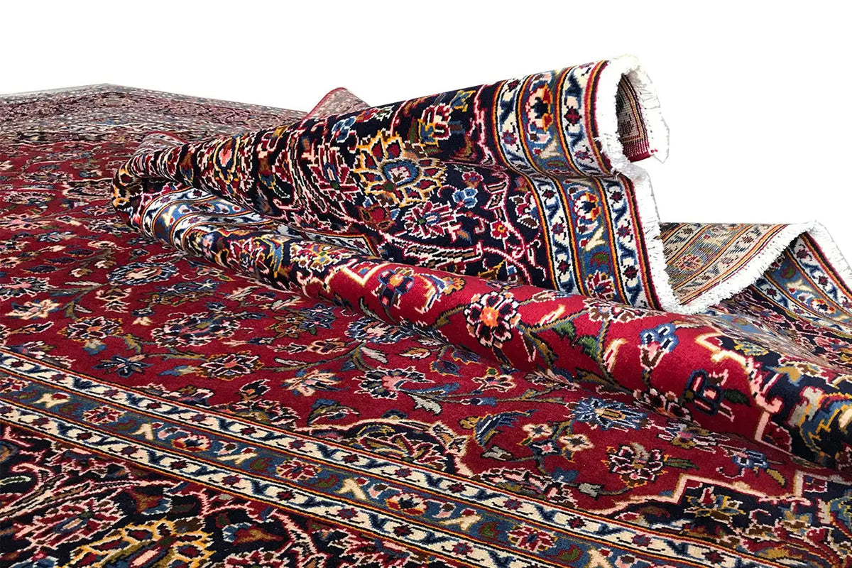 Red Keshan carpet, border pattern with blue-and-white stripes, rolled-up carpet edge