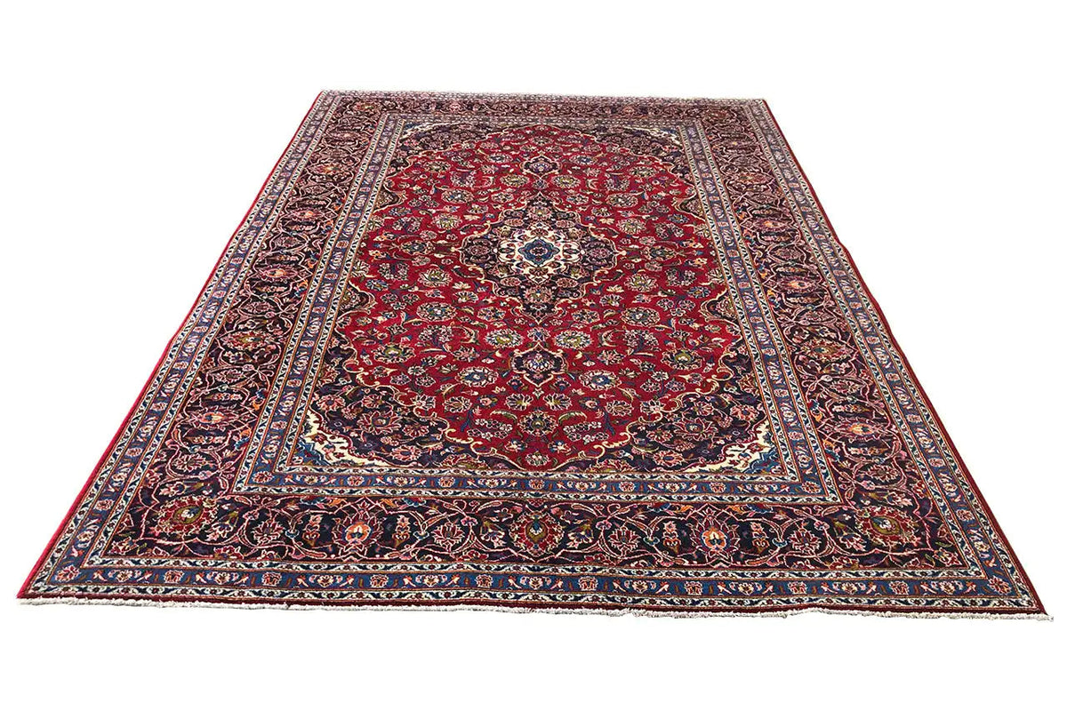 Red Keshan rug with a central medallion and decorative blue border