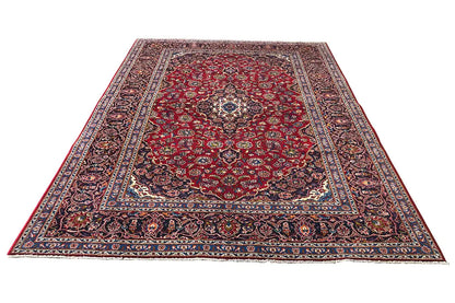 Red Keshan rug with a central medallion and decorative blue border