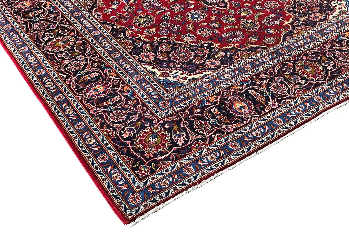 Keshan rug corner, red with a dark blue border and delicate floral ornaments