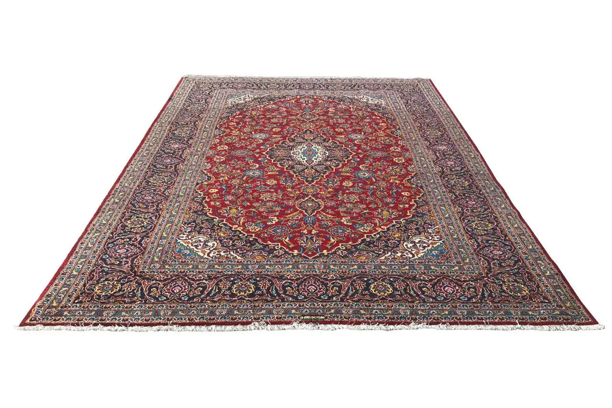 Red Keshan rug with a central medallion, edge ornaments, and wide borders