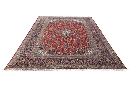 Red Keshan rug with a central medallion, edge ornaments, and wide borders