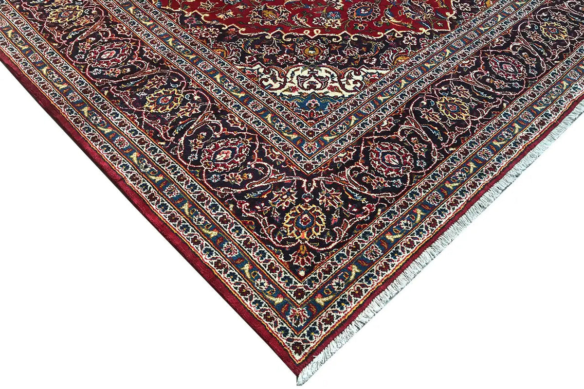 Keshan rug in red: corner area with a dark vine pattern, decorative border and lines