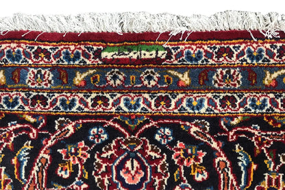 Red Keshan rug with fringed edging and a decorative border along the edge