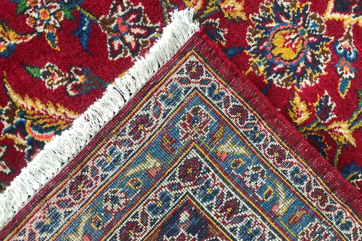 Keshan rug in red with close-up: colorful ornaments and fringes