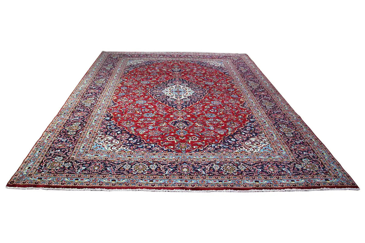 Red and blue Keshan rug with a central medallion and ornamental border, rectangular.