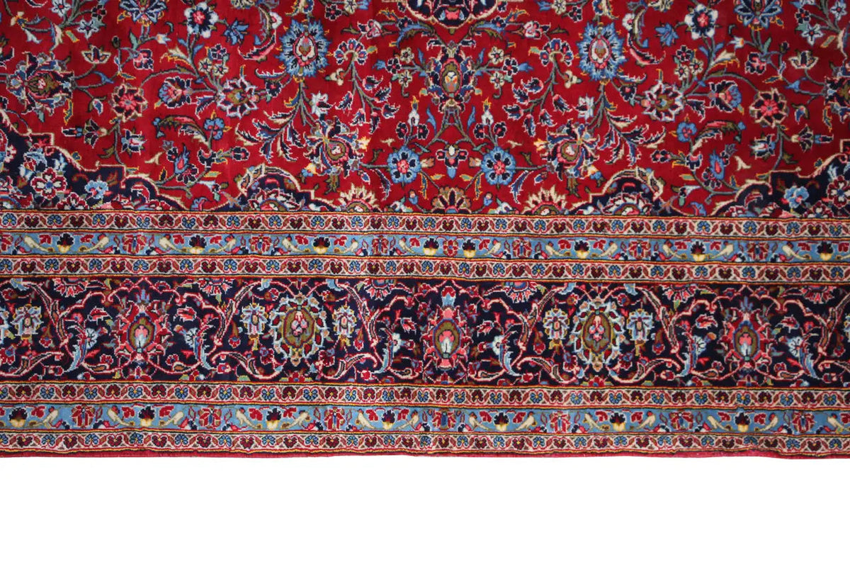 Lower border of a Keshan carpet: red field with ornamental bands and blue accents.
