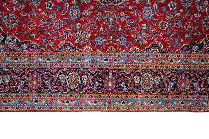 Lower border of a Keshan carpet: red field with ornamental bands and blue accents.