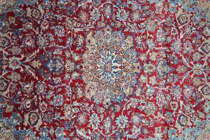 Detailed view: Red-and-blue ornamental pattern on an oriental rug with fine lines.