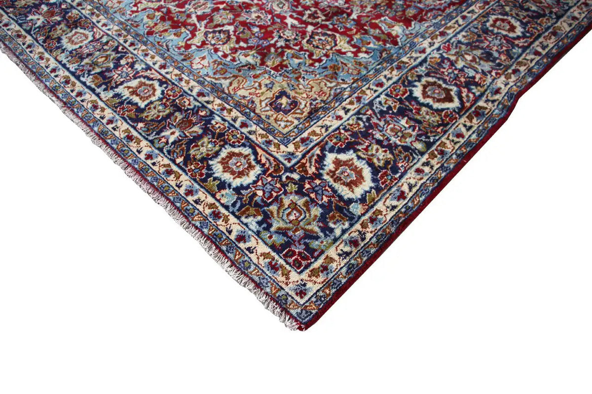 Corner area with a blue border and red ornaments on an Oriental rug.
