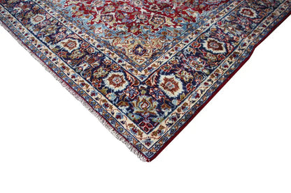 Corner area with a blue border and red ornaments on an Oriental rug.