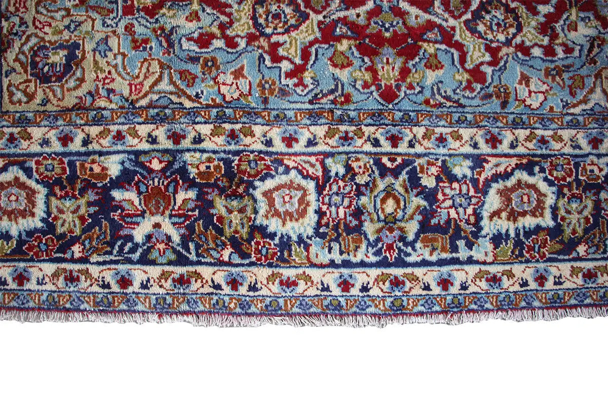 Carpet border along the edge with multicolored motifs and a fringed finish.