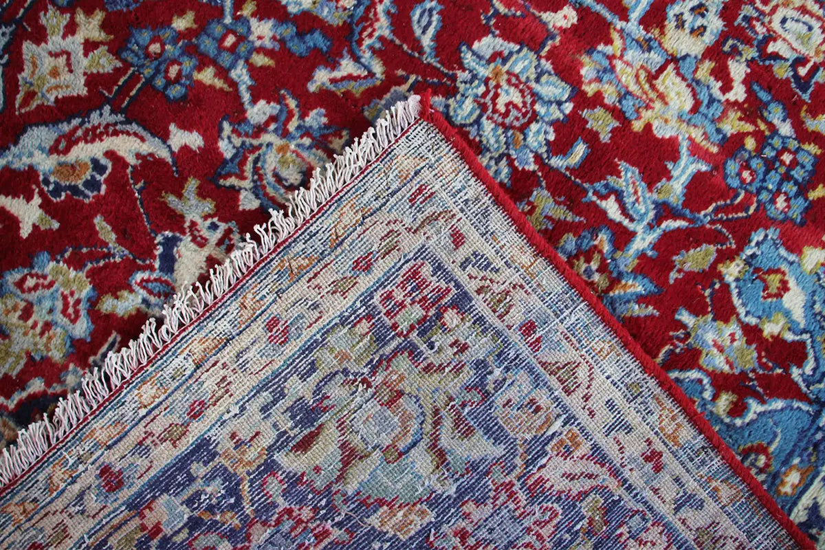 Close-up: Woven ornamental pattern in red, blue and beige along the edge.