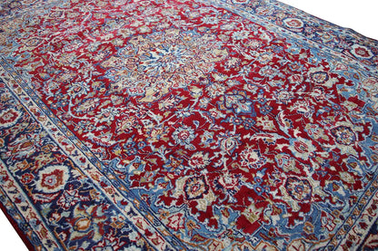 Rectangular oriental rug with a red medallion pattern and blue border.