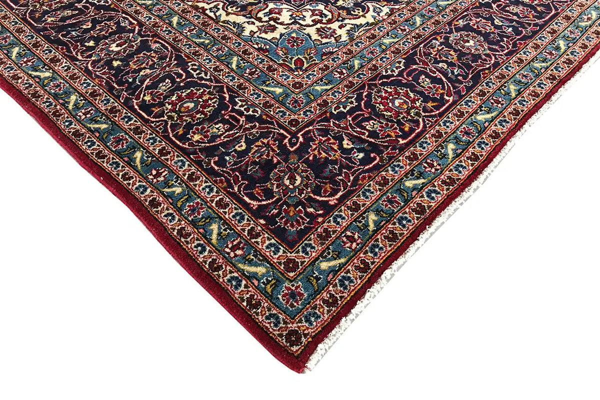 Corner view of Keshan rug: red border with turquoise lines and multicolored ornaments