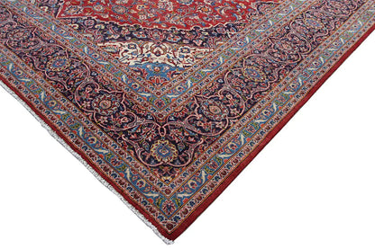 Keshan rug corner detail with a red background and patterned border ornament.