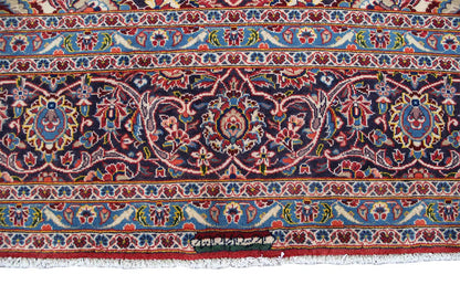 Keshan rug border with fringe along the edge, patterned in dark blue and red.