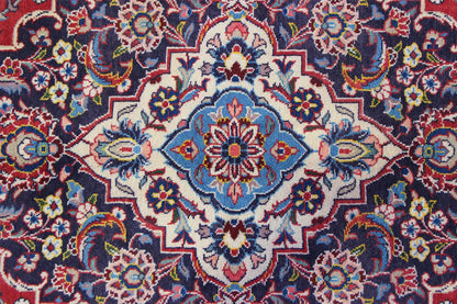 Keshan carpet with a central medallion featuring blue and red floral ornaments, densely patterned.