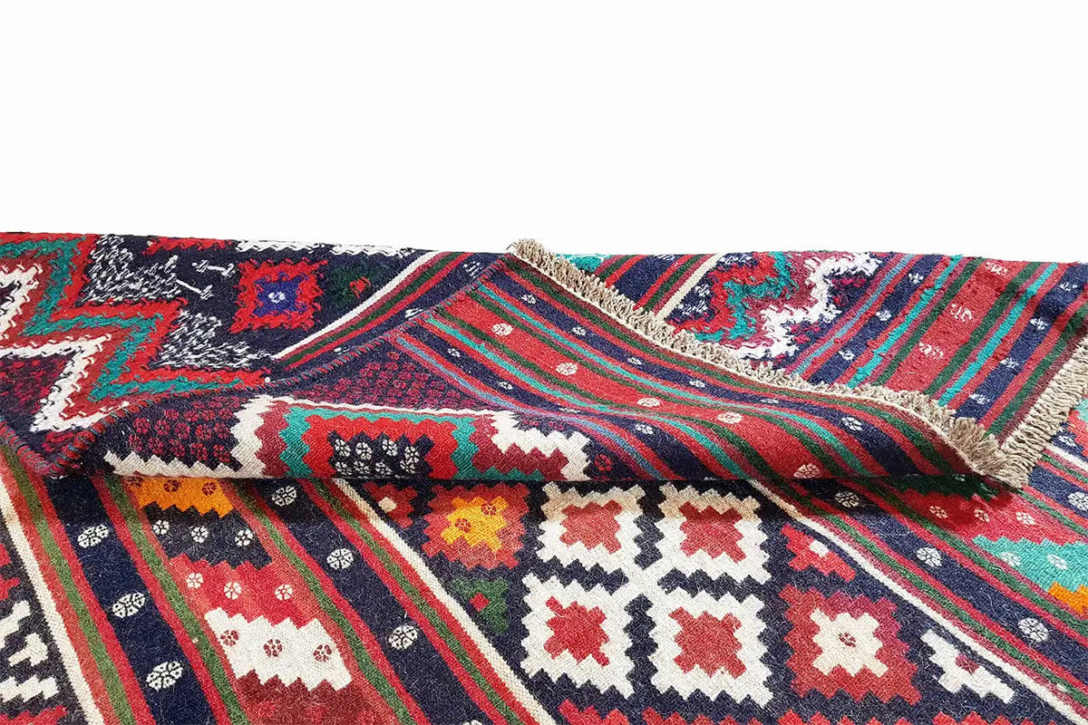 Kilim rug detail with a braided-looking edge; striped pattern in red, blue, green, and white.