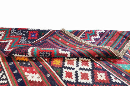 Kilim rug detail with a braided-looking edge; striped pattern in red, blue, green, and white.