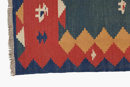 Kilim rug detail: multicolored border with geometric patterns and fringes