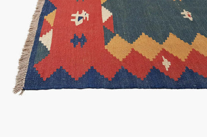 Kilim rug detail below: blue fields, red and yellow areas, side fringes