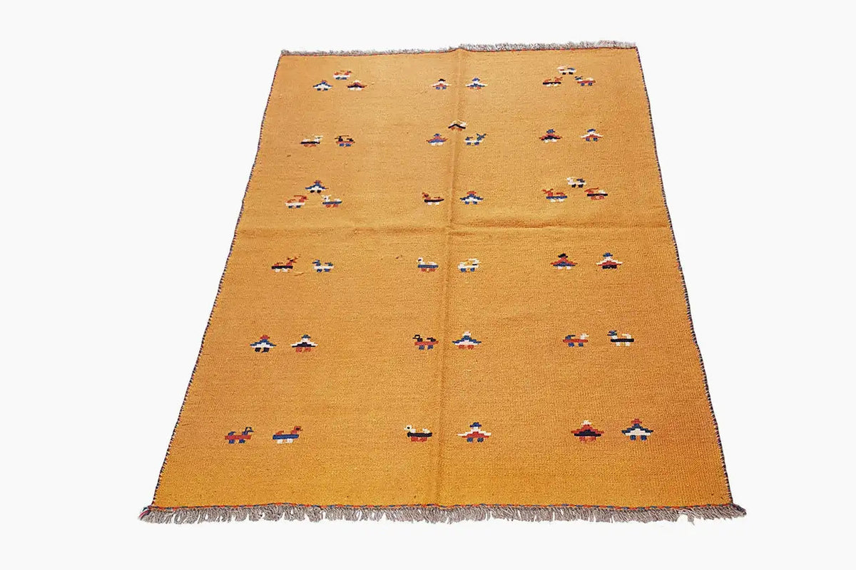 Ochre-brown kilim rug with colorful ornaments and fringed edges